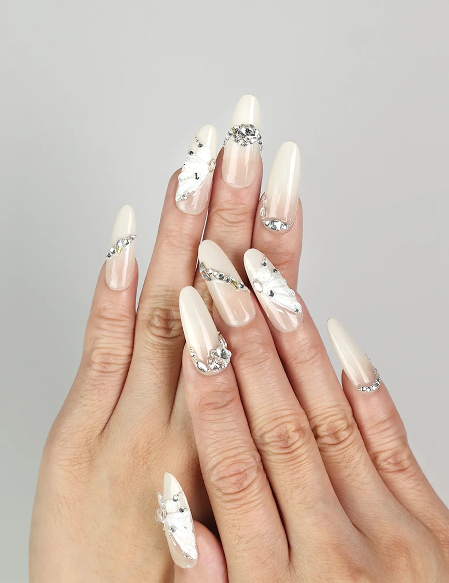 Model wearing Glimmer Mirage translucent handmade Singapore press-on nails with silver glitter and butterfly accents by naillover