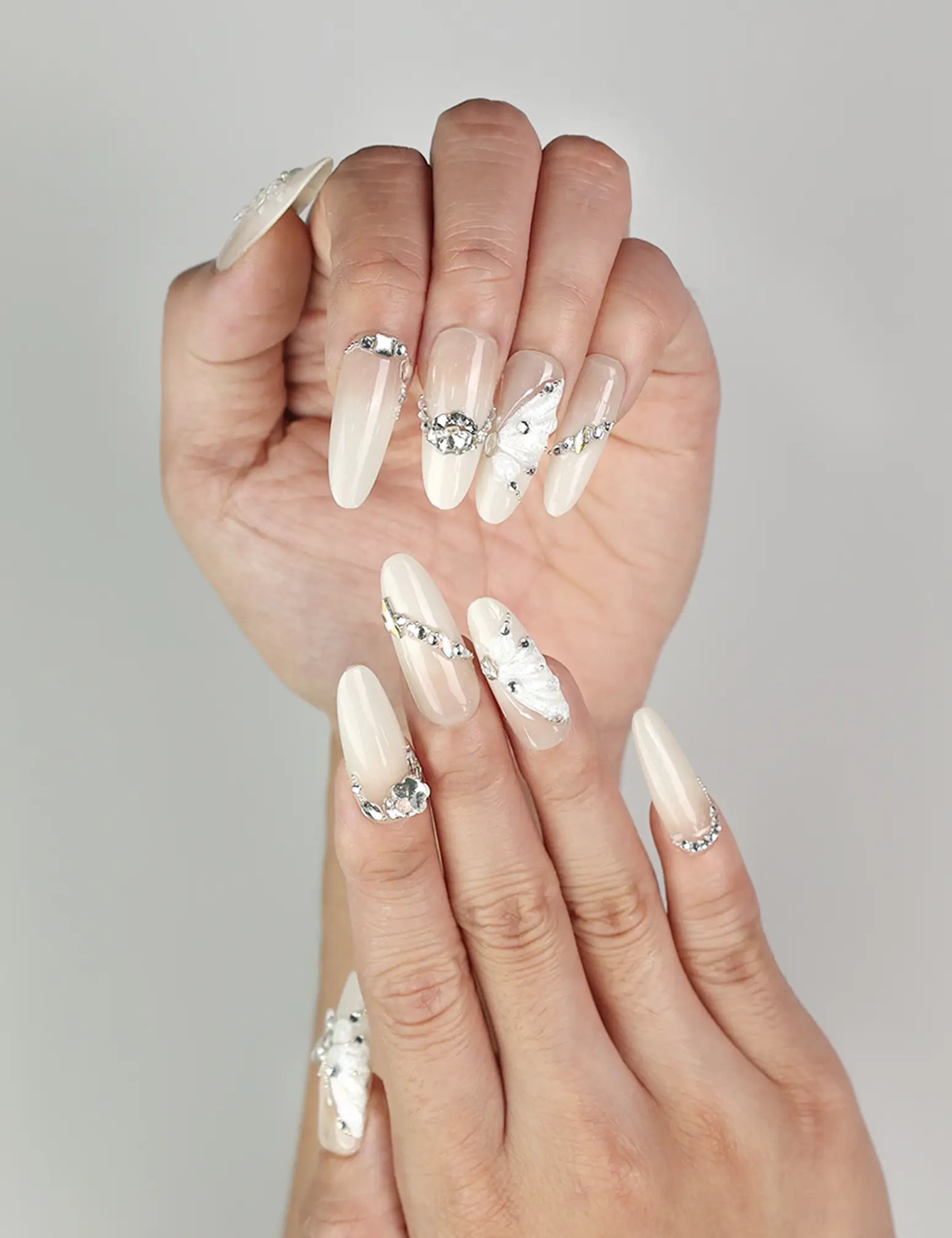 Close-up of Glimmer Mirage translucent handmade Singapore press-on nails with delicate shimmer and butterfly accents by naillover
