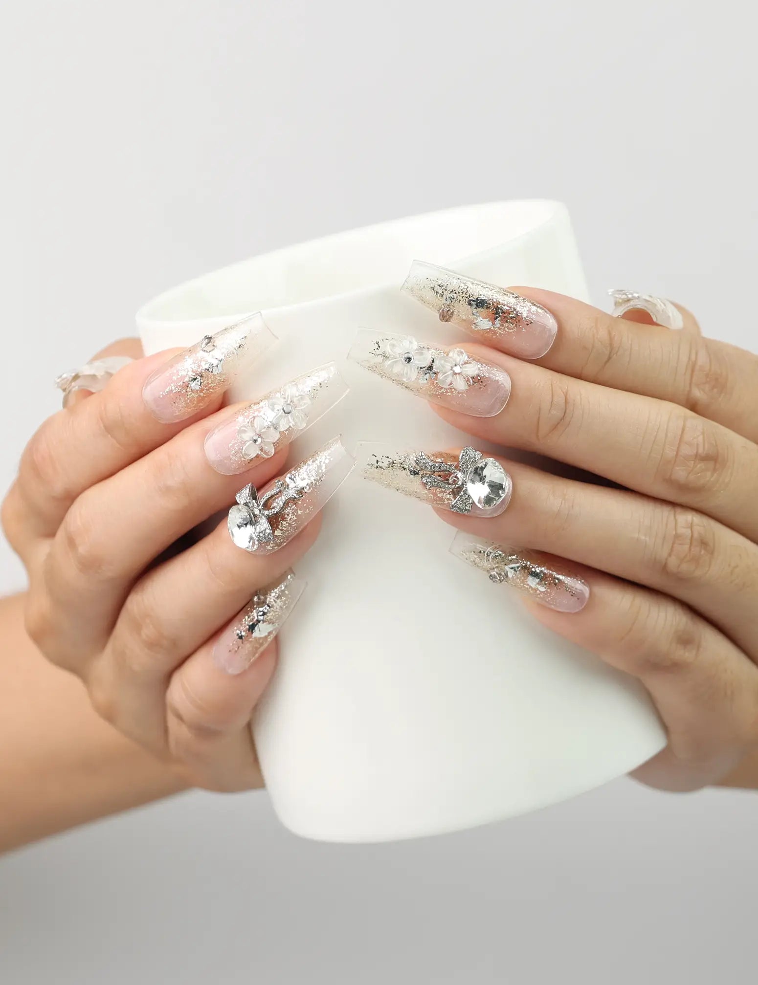Model holding a cup wearing Glisten Dream handmade Singapore press on nails with silver glitter by naillover