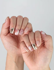 Side view of short square press-on nails featuring red base, golden foil layers, and raised flower nail art