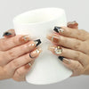 Model holding a coffee cup wearing Gold Tips Singapore press on nails with nude base, gold details, and pearl embellishments – handmade by naillover
