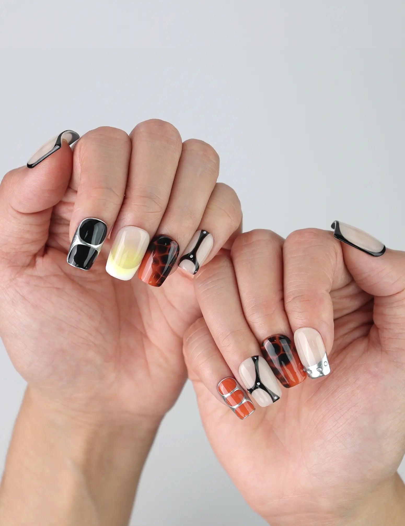 Hands fanned out to highlight handmade short square nails with a luxe gold gloss and soft caramel veining by Naillover