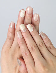 Hand gesture showcasing pale pink short press on nails with fine gold lines and soft shimmer, handmade in Singapore by Naillover