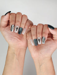 Gothic Cross trendy nails styled on hand, highlighting silver and black cross designs in natural light