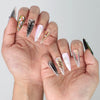 Stylish hand pose highlighting the iridescent chrome glow and embedded gems on stiletto press on nails by Naillover