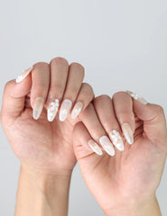 Fingers gracefully posed to display Naillover’s Singapore handmade press on nails with ivory tones and pearl 3D art