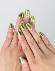 Hand model wearing short square green chrome press-on nails with high-shine mirror effect and rich emerald tones