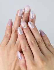 Hand gesture showing lavender gradient press on nails with soft pink, white, and holographic accents by Naillover