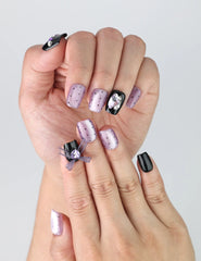 Close-up of Naillover’s short black and purple square nails featuring sparkling heart gems and cute 3D kawaii details