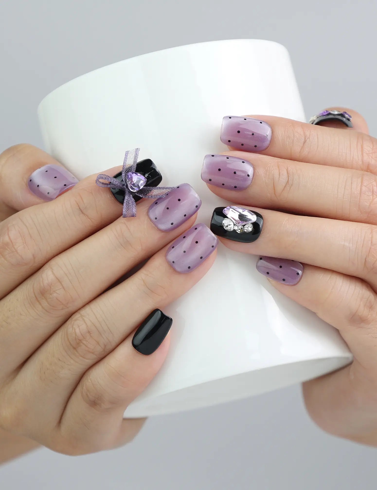 Side view of handmade square press-on nails in deep purple and black with glossy finish and charming kawaii elements
