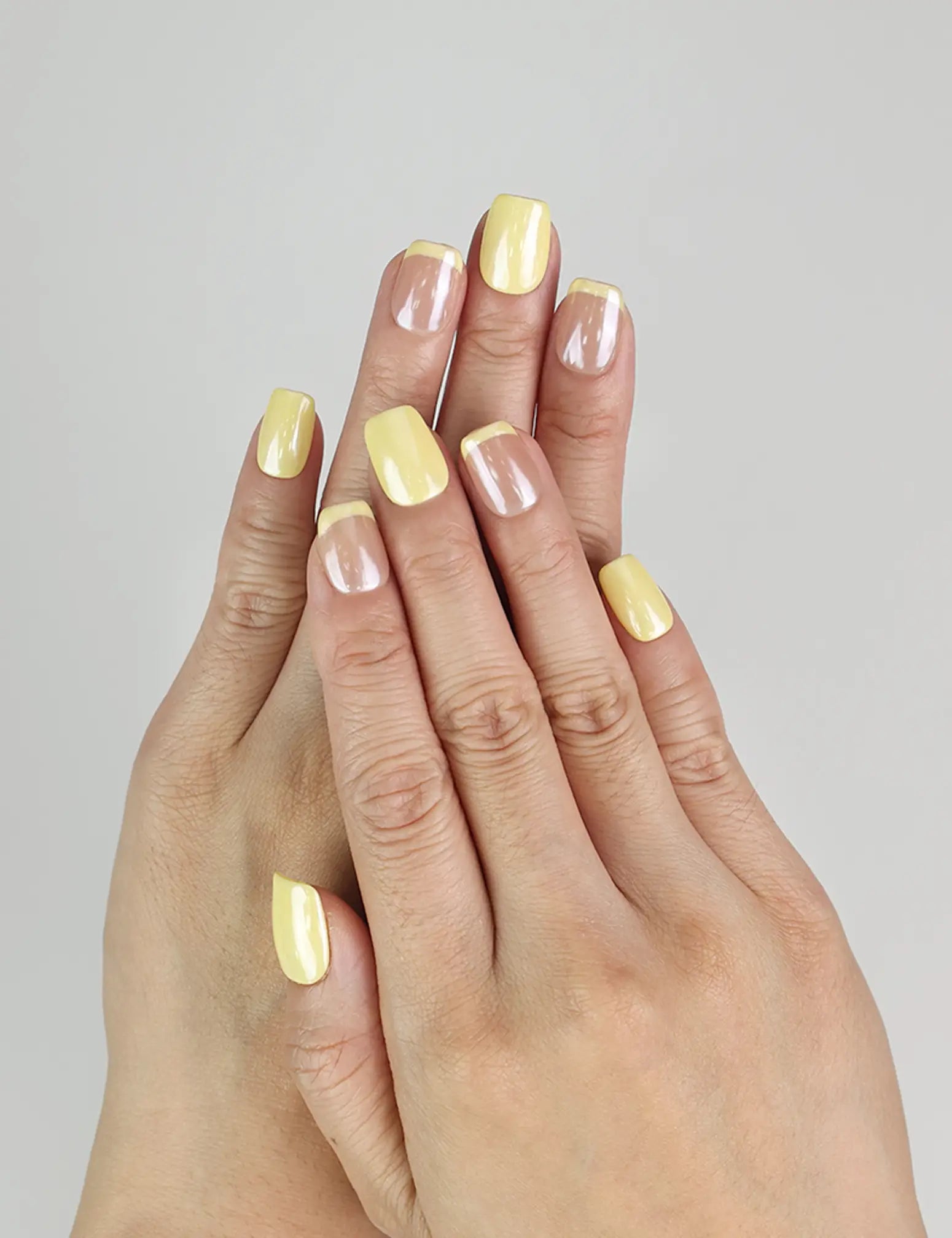 Close-up of Lemon Zest Singapore press on nails on hand, yellow to pink ombre summer nail design by naillover