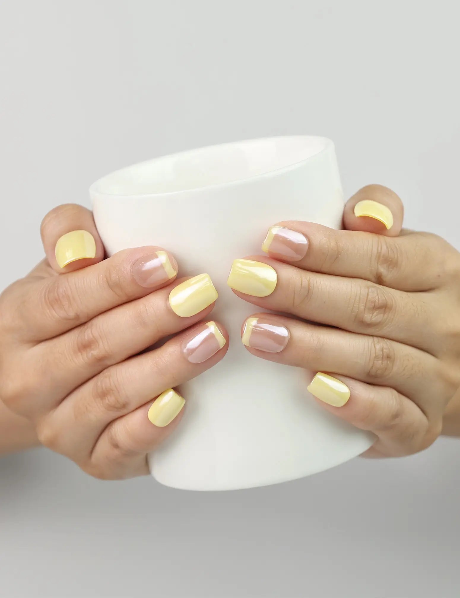 Lemon Zest handmade Singapore press on nails holding a coffee cup, yellow-pink ombre summer cute nails by naillover