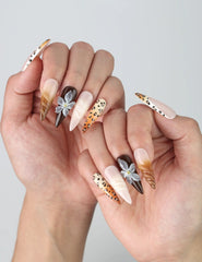 Side view of dramatic stiletto nails combining leopard spots, sleek black polish, and handcrafted floral nail art