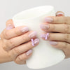 Naillover Lilac Whisper Singapore press on nails holding a teacup, showing beige base and lavender ribbon details