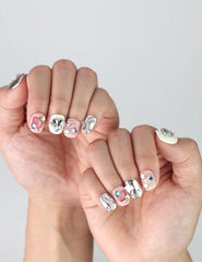 Side angle of short square press-on nails featuring soft chrome pink tones and raised 3D heart and star nail art