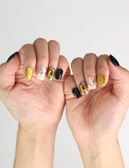 Side angle view of hand wearing Luxe Mix black, gold, glitter Singapore press on nails with gem accents, naillover