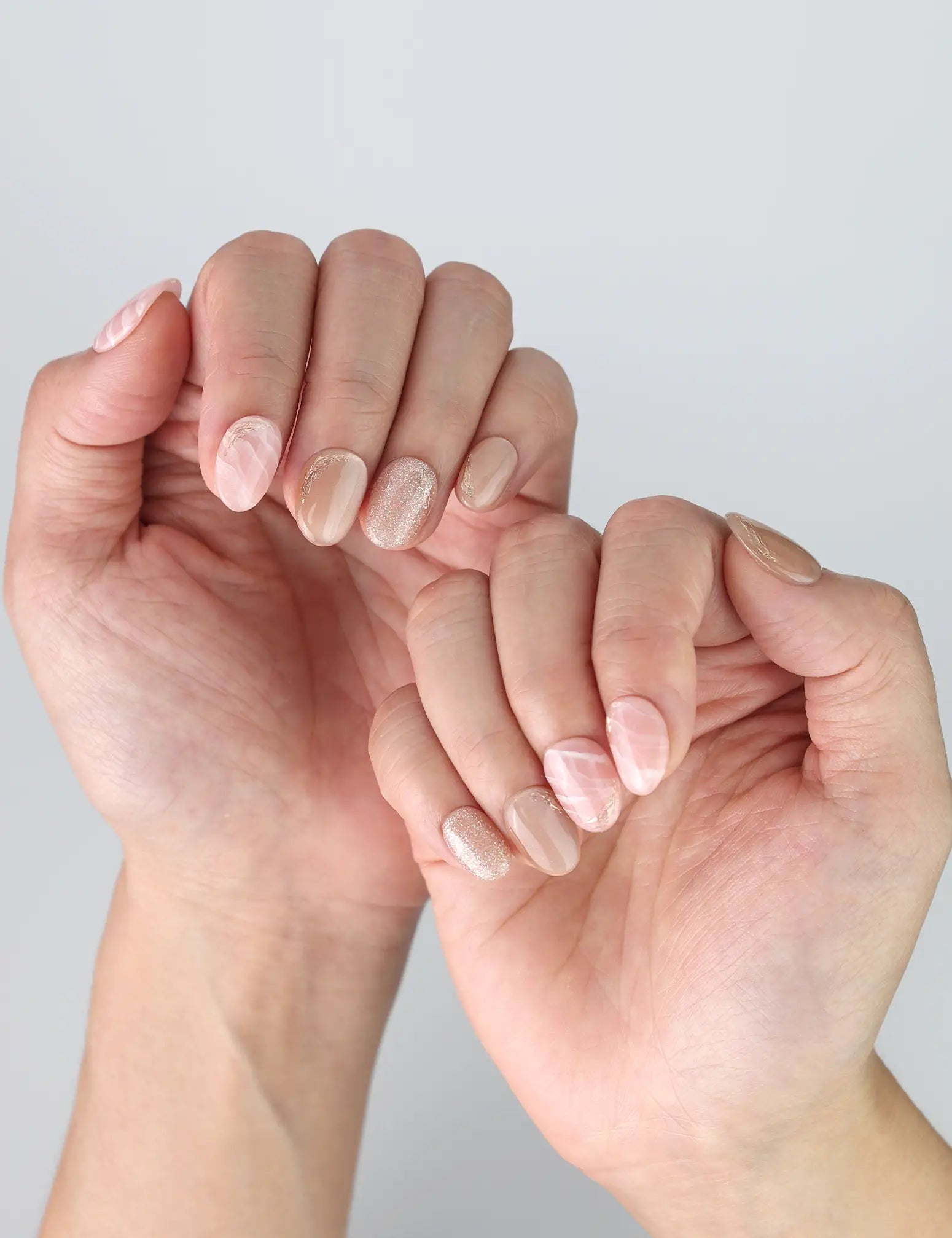 Casual hand pose wearing Naillover Singapore press on nails in pink and white marble for everyday elegance.