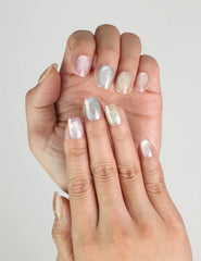 Close-up of fingers with Mermaid Glaze pastel pearl press on nails, showing dreamy pinks and purples