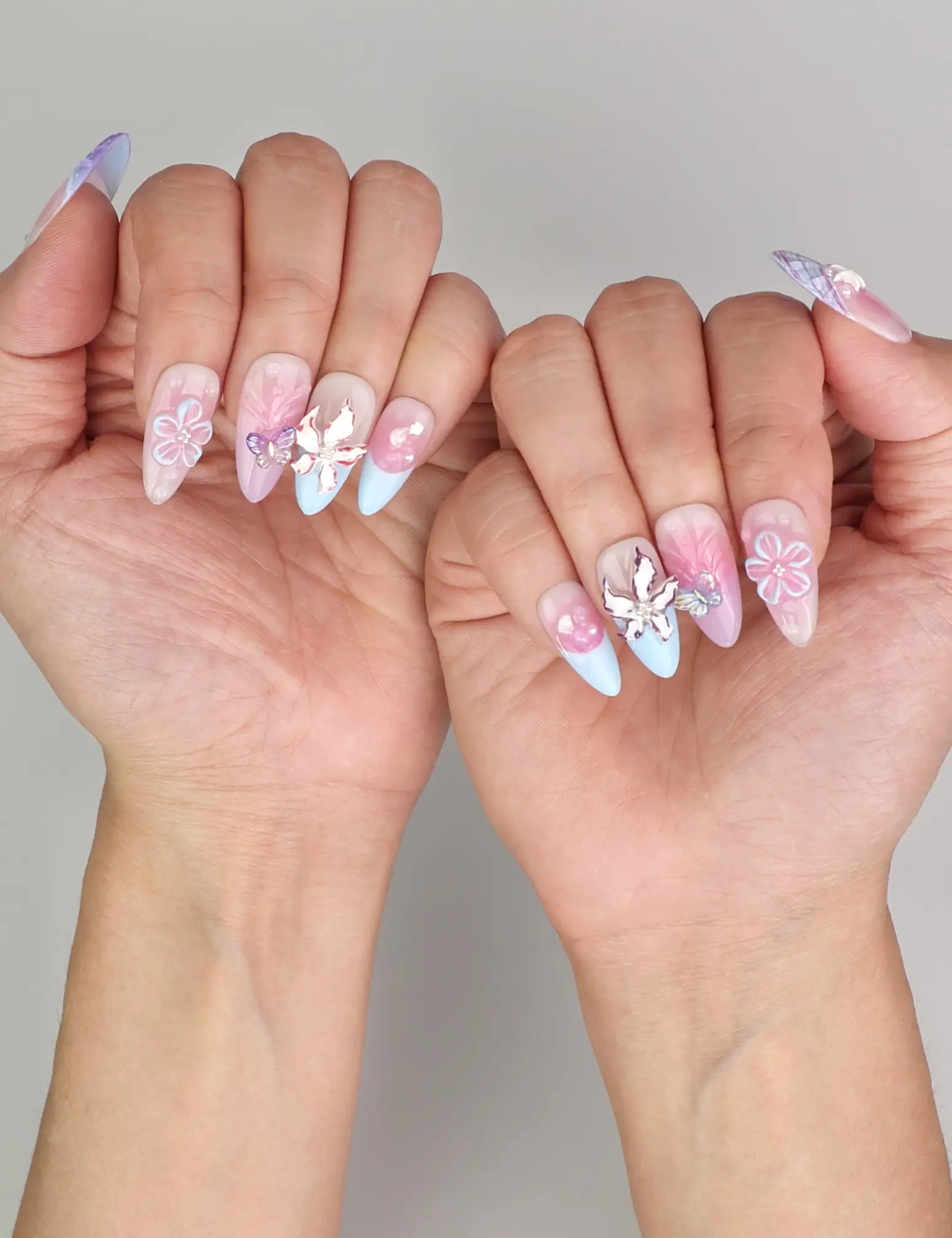 Naillover Mermaid’s Floral Dream trendy nails styled on hand, showcasing pink and blue gradient with delicate 3D decorations.