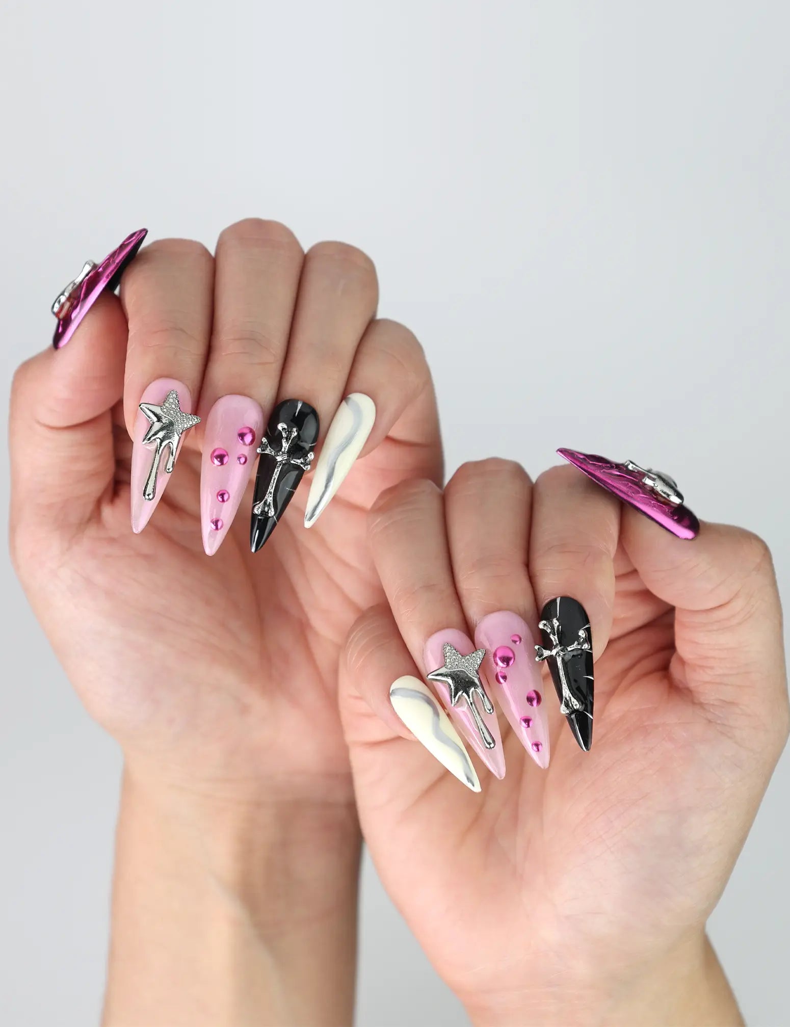 Side view of handmade Singapore stiletto nails with glossy finish, decorated with layered heart and star designs