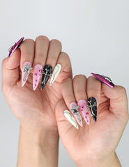 Side view of handmade Singapore stiletto nails with glossy finish, decorated with layered heart and star designs