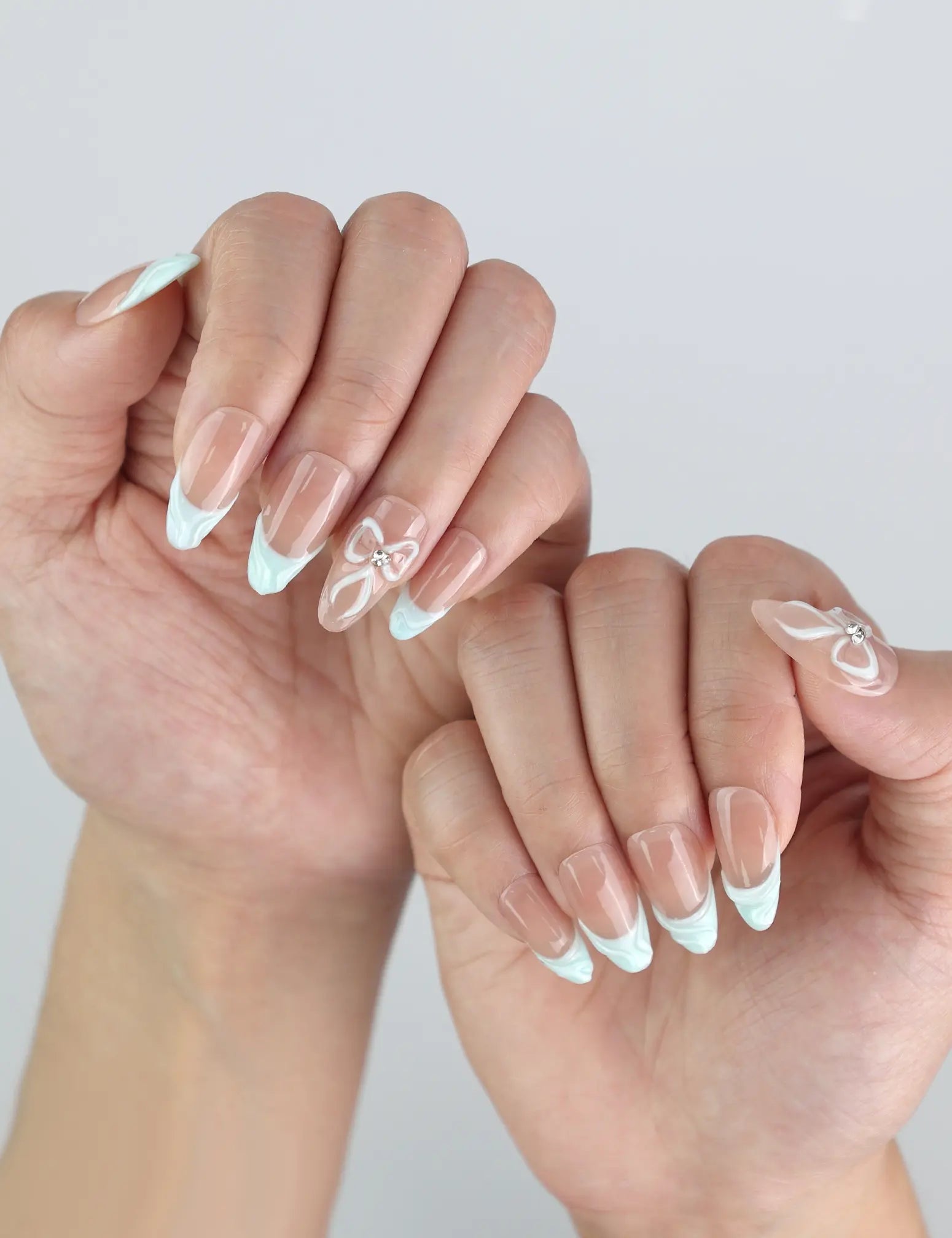 Side angle of fingers with Naillover Mint Chic handmade press on nails, featuring coquette-style bows and a glossy finish.
