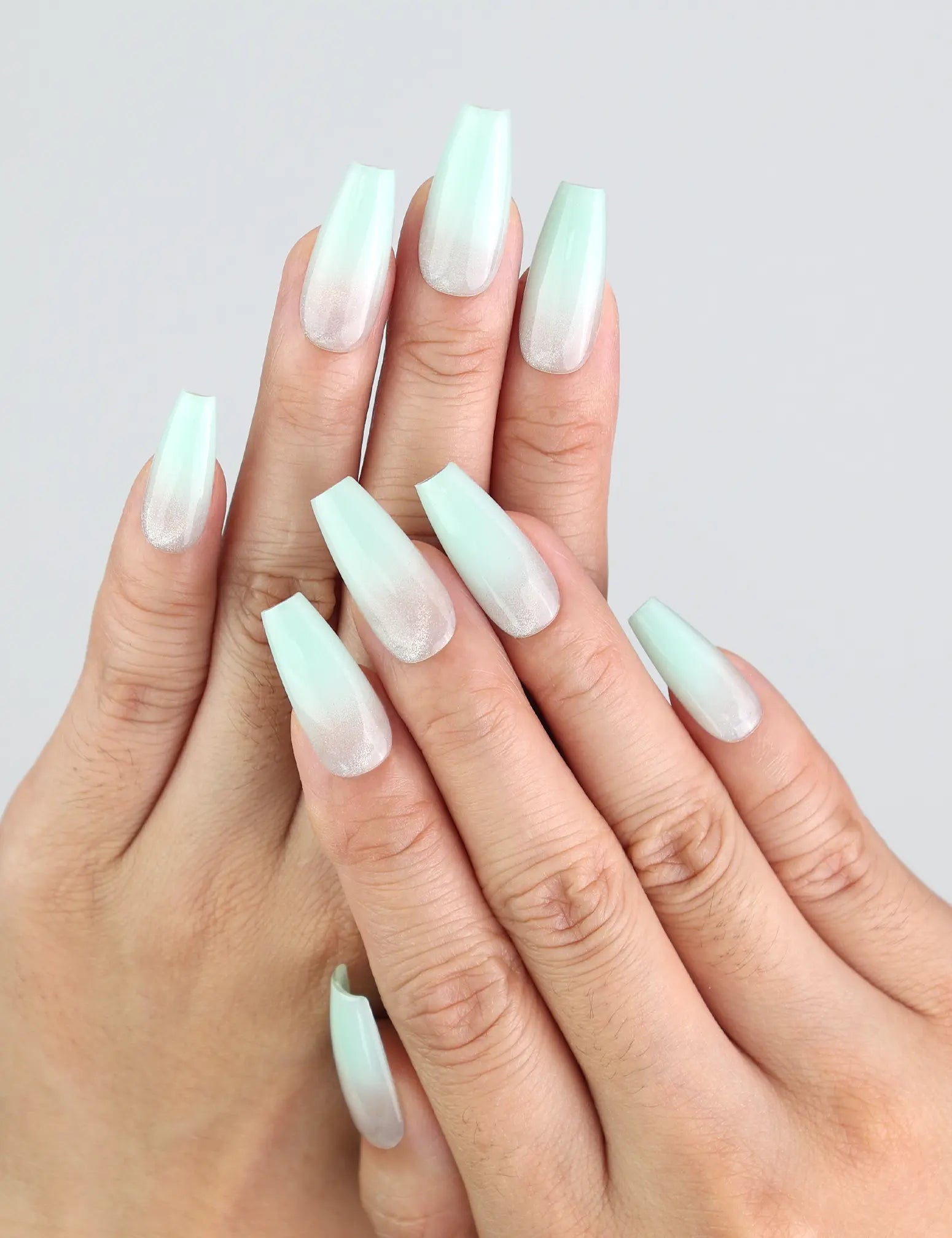 Hand wearing Naillover Misty Blue Fade coffin nails, showcasing gradient from misty grey to soft blue.