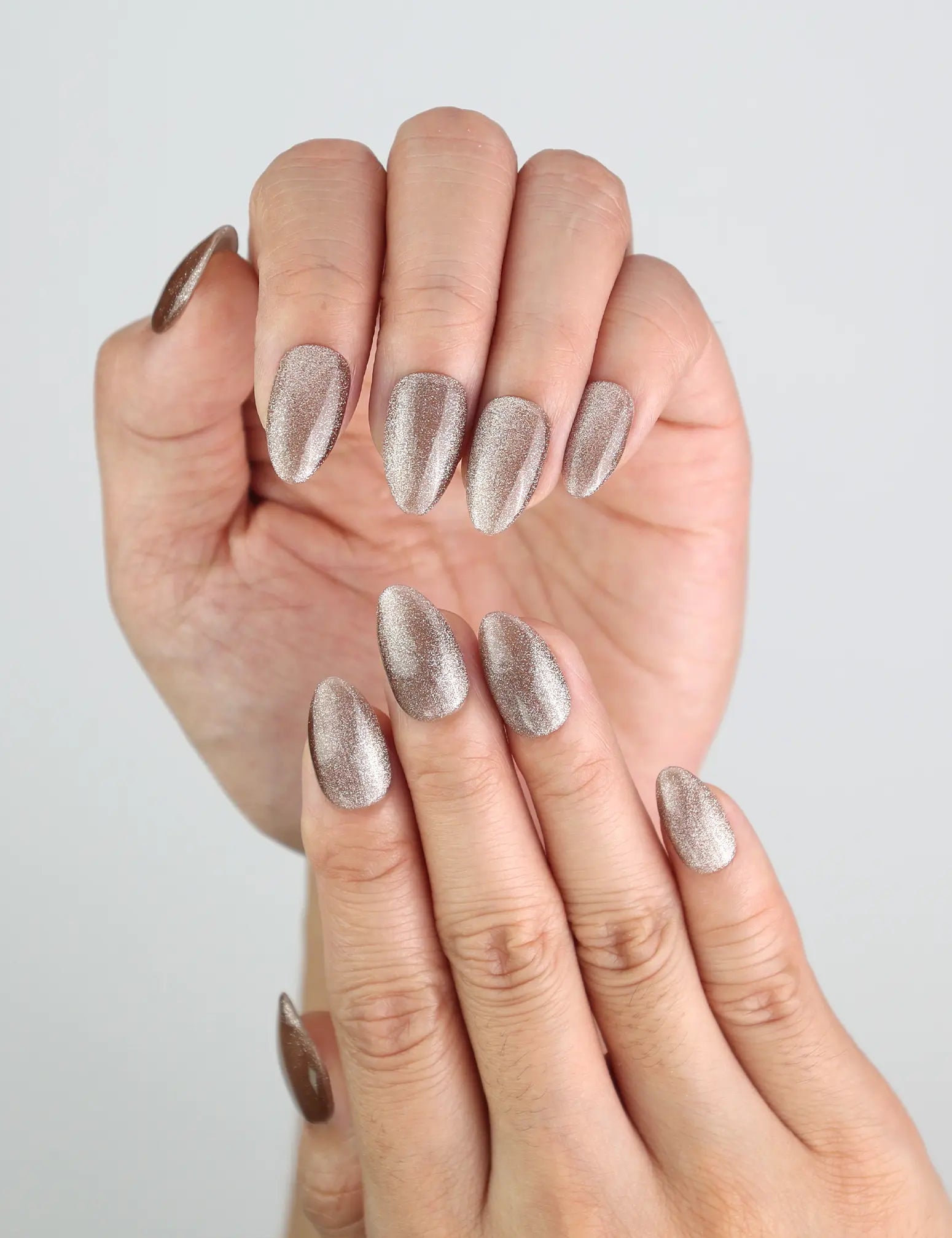 Close-up of Mocha Gleam Singapore press on nails on hand, showing magnetic brown shimmer in natural light.