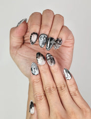 Close-up of Naillover Moonlit Noir Singapore press on nails featuring chrome swirls, studs, and star embellishments.