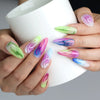 Hand holding a cup, showcasing Naillover’s flaming almond nails with neon red accents and a bright, glossy base