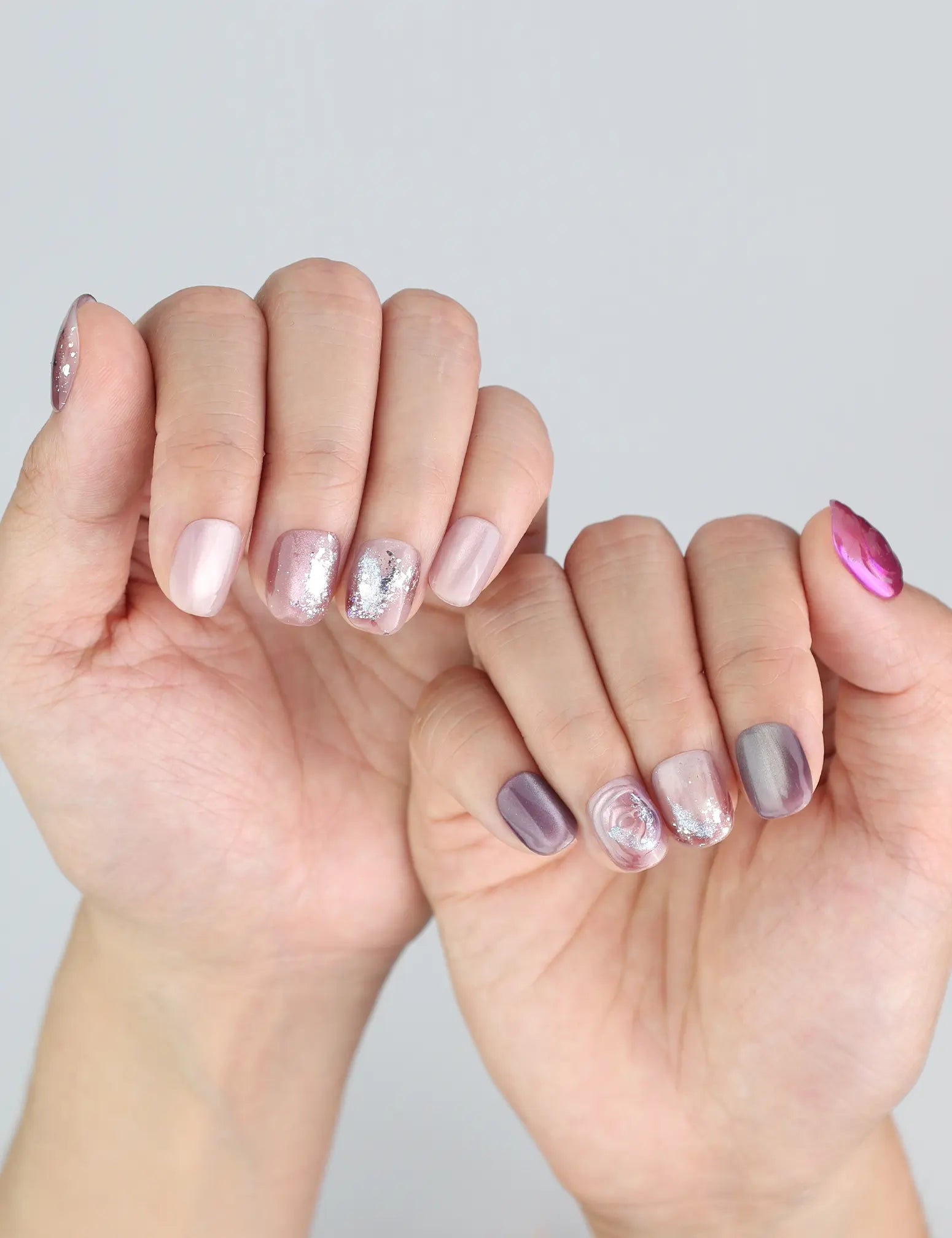 Close-up of Naillover handmade press on nails in Amethyst Shimmer—subtle French magnet and carved floral.