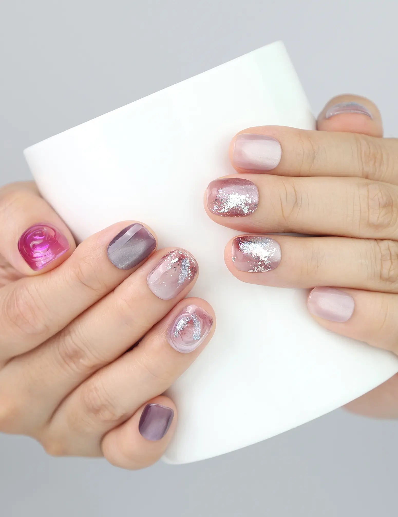 Naillover Amethyst Shimmer press on nails worn while holding a cup, elegant and artsy short nail look.