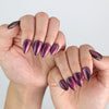 Natural daylight shot of hands showcasing Naillover Amethyst press on nails in rich purple tones.