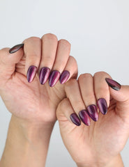 Natural daylight shot of hands showcasing Naillover Amethyst press on nails in rich purple tones.