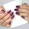 Woman holding a coffee cup while wearing Amethyst cat eye press on nails by Naillover.