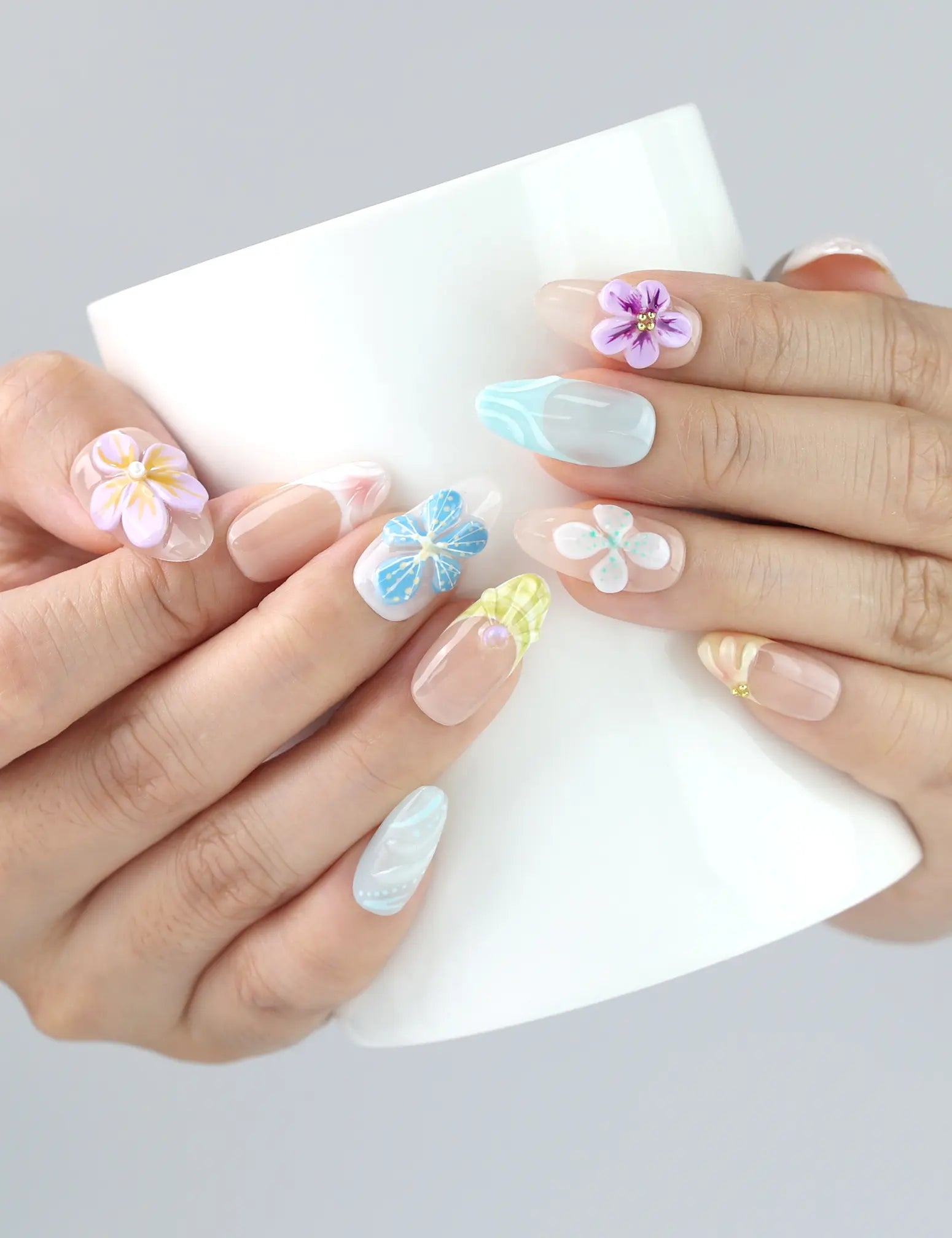 Naillover Bloom Harmony press on nails shown holding a drink — pastel floral nails from Singapore with charming 3D details, perfect for brunch looks.