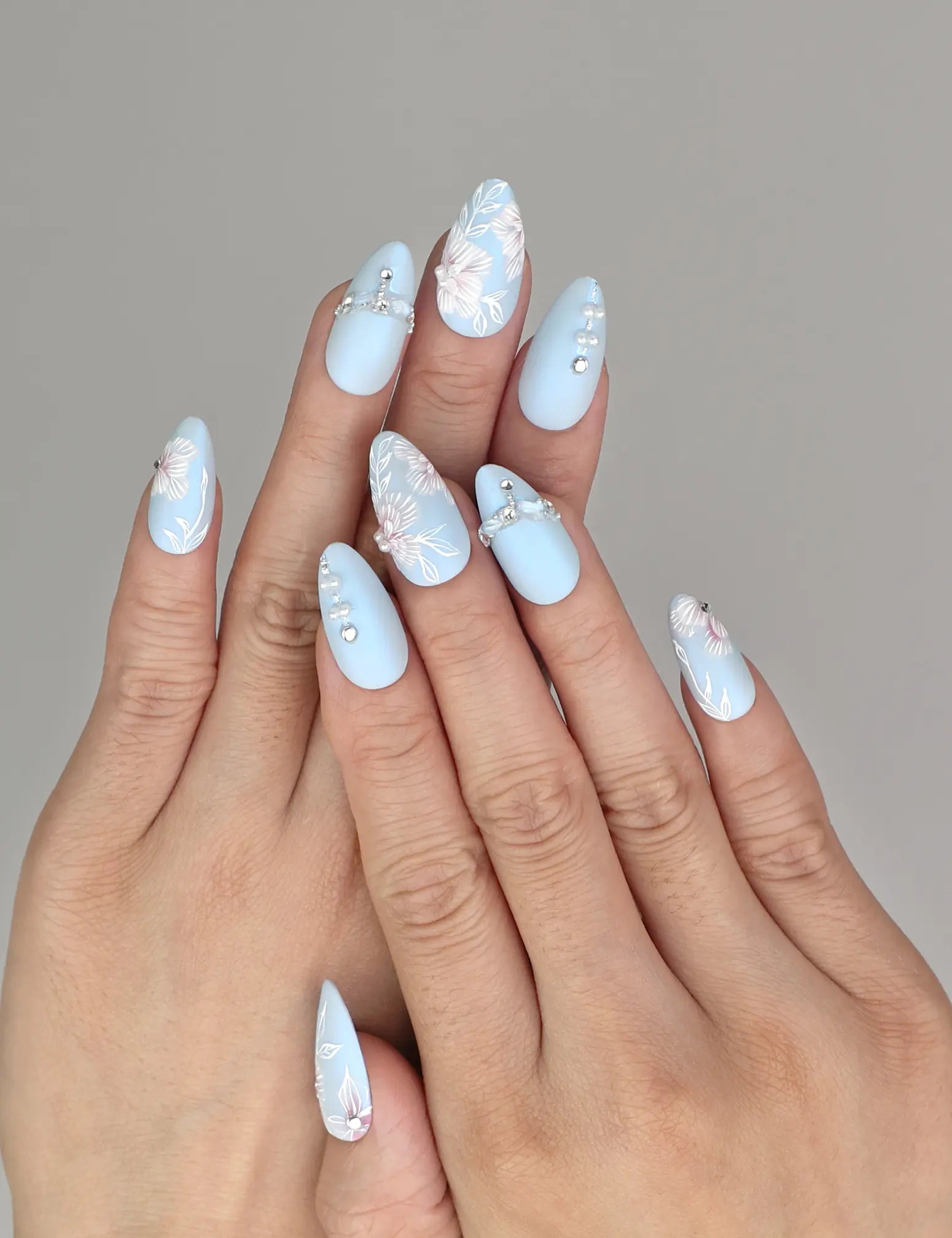 Model wearing Naillover Blue Floral Diamond Singapore press on nails with matte blue base and delicate white floral accents