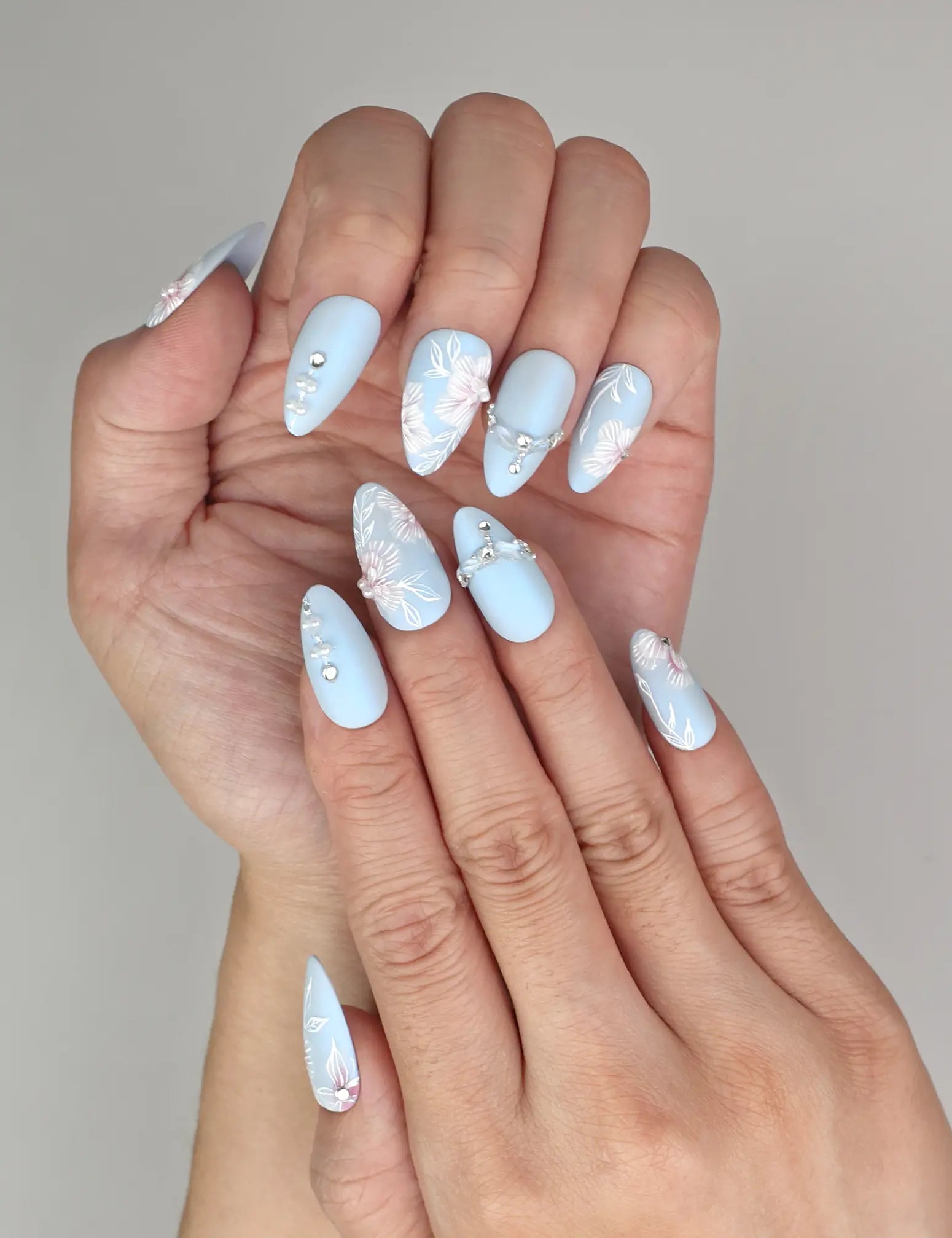 Close-up of Naillover Blue Floral Diamond handmade press on nails showing floral patterns and pearl crystal details