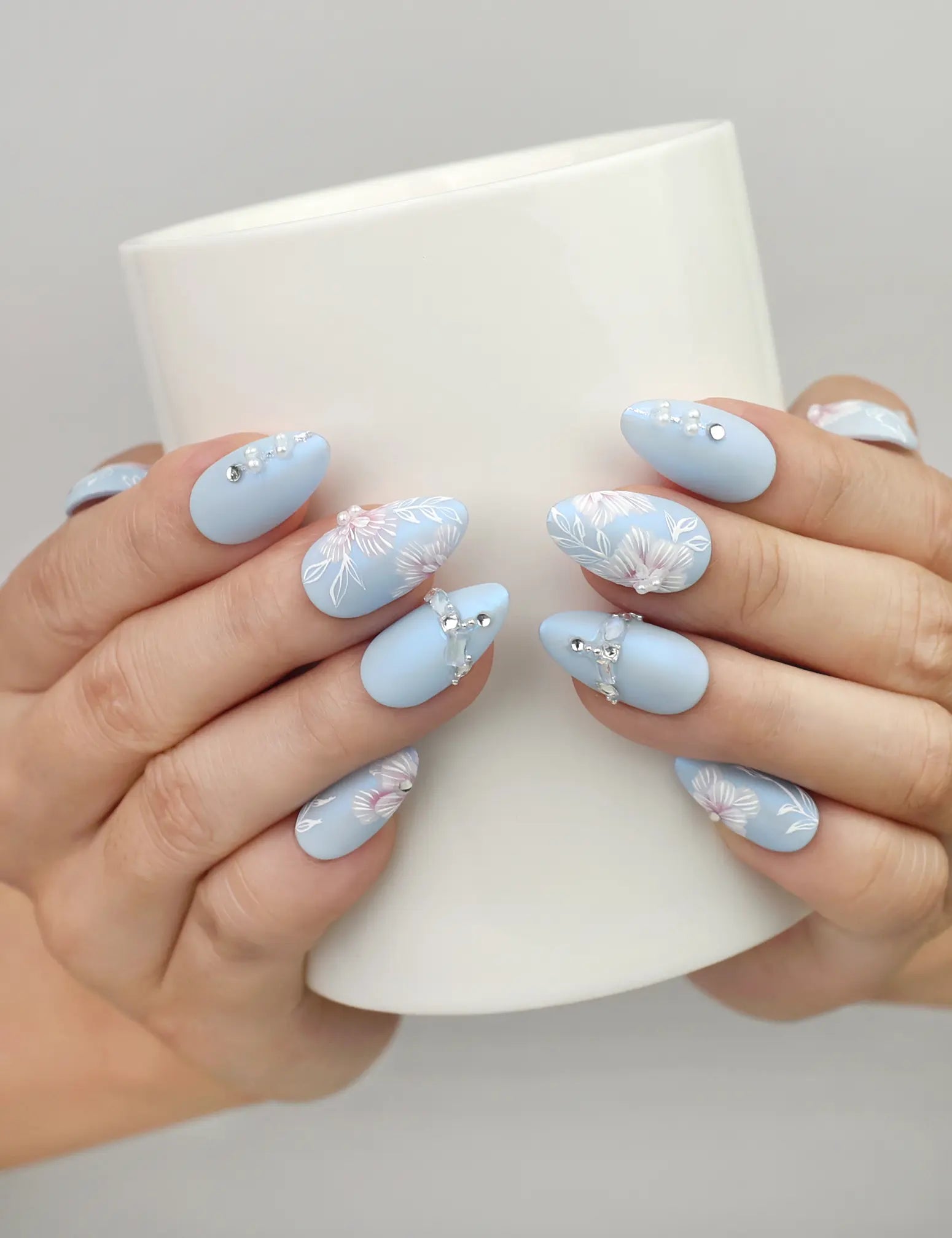 Naillover Blue Floral Diamond press on nails SG shown while holding a cup, featuring floral art with pearls and crystals