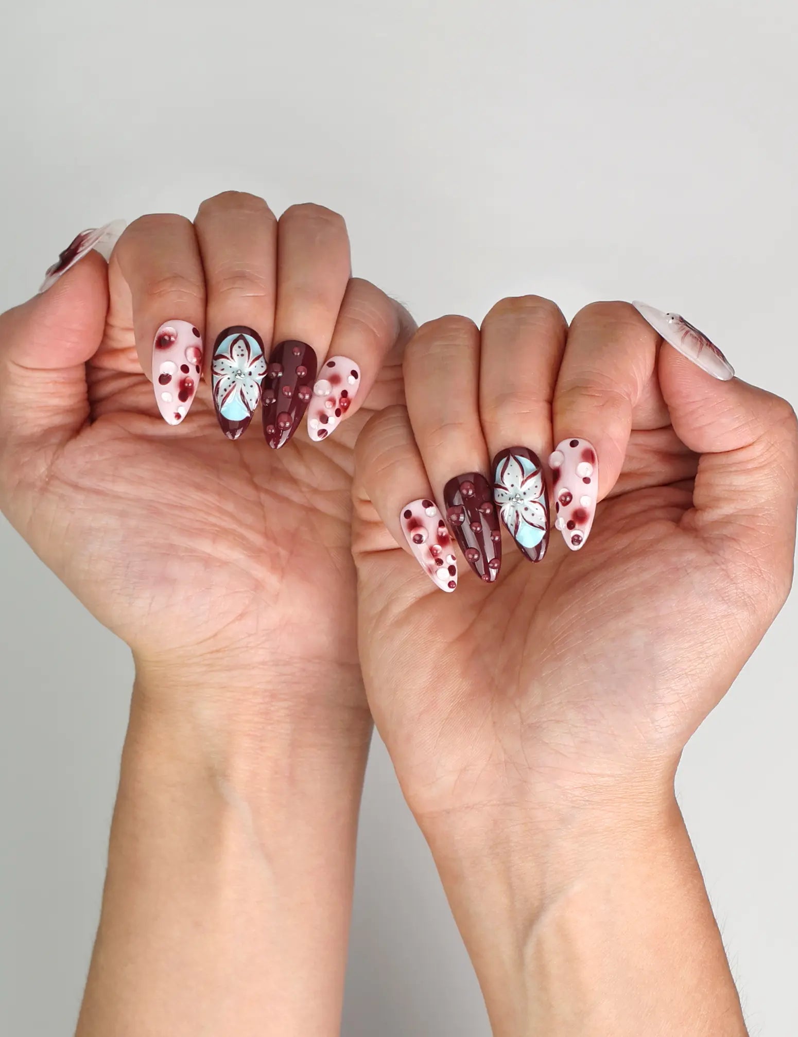 Naillover Blush Enigma trendy nails styled with outfit, highlighting chic burgundy and white nail art.