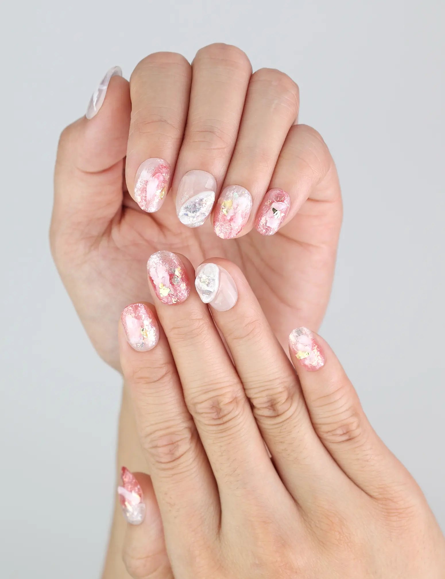 Close-up of Blush Gold handmade press on nails with marbled pink tones and delicate 3D summer accents.