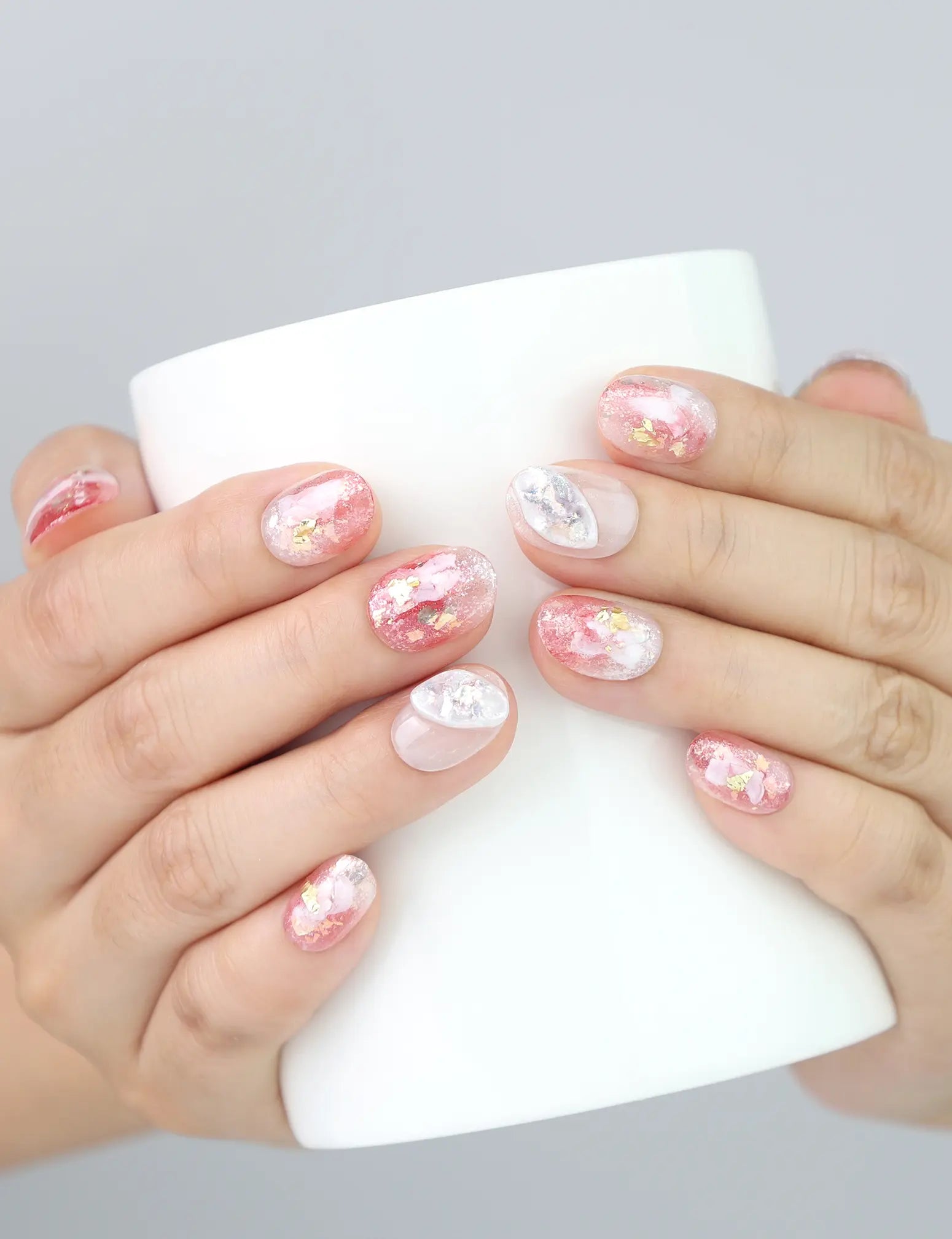 Blush Gold handmade press on nails worn while holding a glass, showcasing beachy chic nail details in natural light.