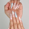 Close-up of Naillover Butterfly's Dream 3D summer nails in soft pastel tones with shimmering gold accents.