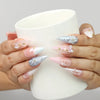 Model holding a cup while wearing Naillover Butterfly's Dream Singapore press on nails with pastel floral motifs.