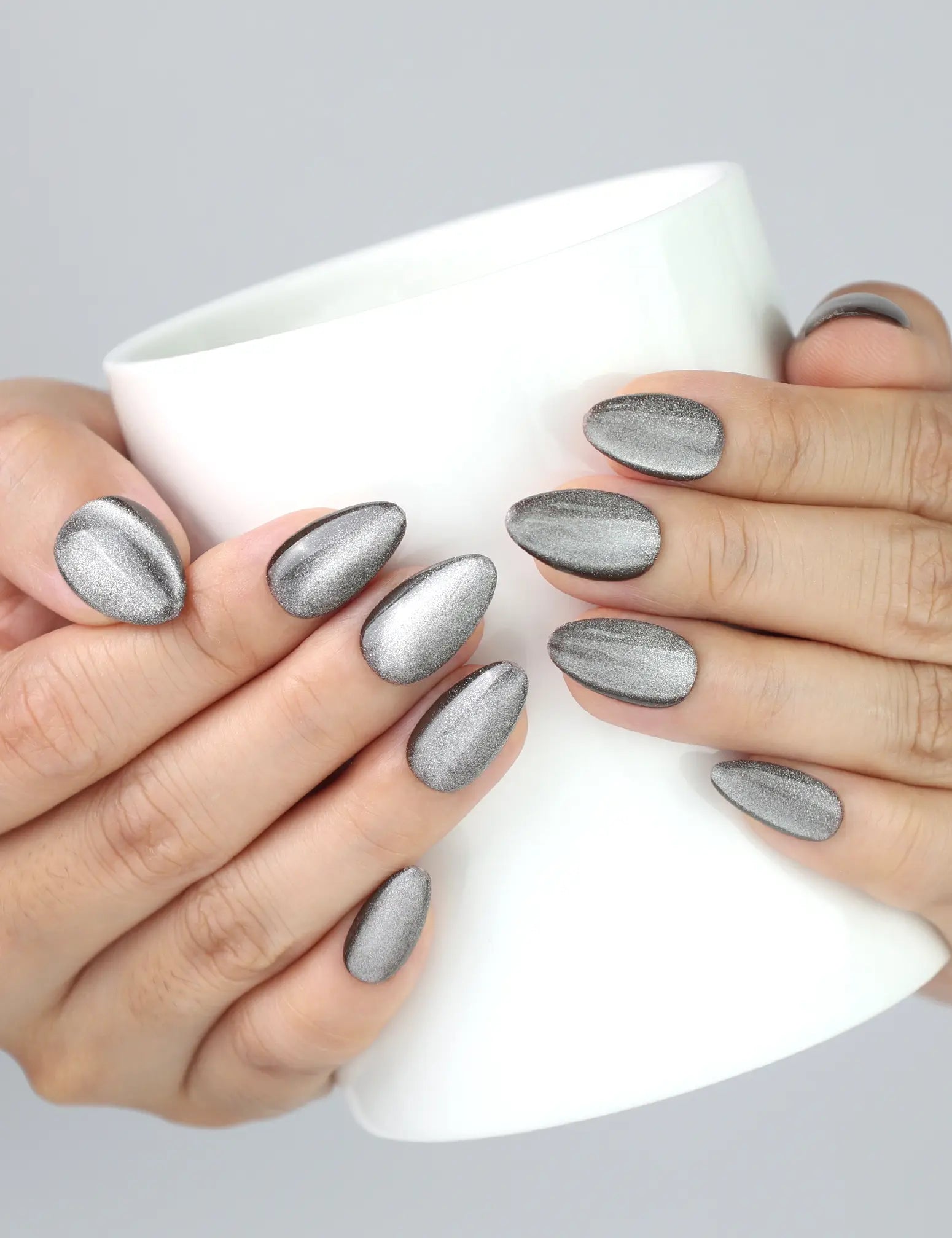 Holding a coffee cup with Naillover Chestnut Tone press on nails, showing natural silver cat eye glow.