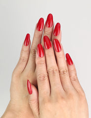 Hand wearing glossy ruby red medium oval handmade Singapore press on nails by Naillover, classic and elegant style