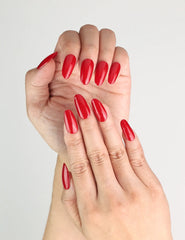 Close-up of glossy ruby red handmade Singapore press on nails in medium oval shape by Naillover