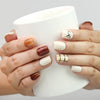 Hand holding a cup while wearing Naillover Cocoa Grid handmade press on nails, perfect for everyday chic style.