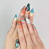 Model wearing Cosmo Glam handmade Singapore press on nails in vibrant Y2K style with retro patterns