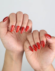 Angled view of fingers with Naillover Crimson Magnet nails, highlighting rich red tones and glossy cat-eye finish.